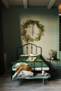 Interior of a bedroom with a large bed in green, decorated for christmas and new year