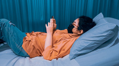 Midsection of woman resting on bed