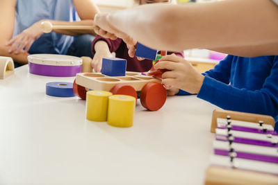 Close-up of children playing with musical instruments and toys in kindergarten