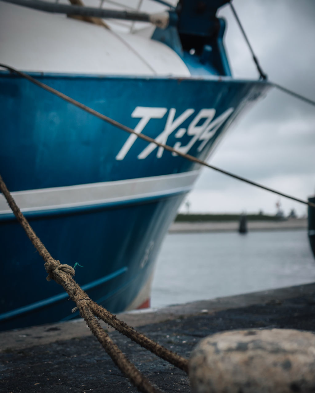 nautical vessel, water, transportation, blue, rope, sea, mode of transportation, vehicle, moored, sailboat, no people, ship, boat, nature, harbor, mast, day, sailing, outdoors, sailing ship, anchor - vessel part, sky, tied up, pier, focus on foreground, travel, anchored, close-up, selective focus