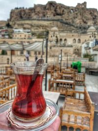 Close-up of drink on table against buildings in city