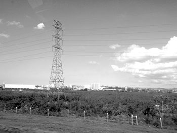 Electricity pylon on field against sky