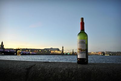 Bottle by sea against sky at sunset