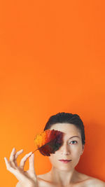 Portrait of young woman holding orange