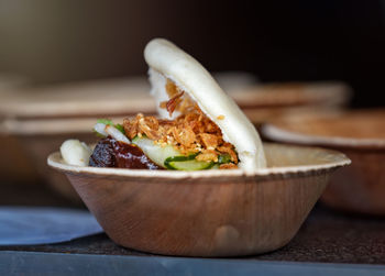 Close-up of asian food in wooden bowl at market stall