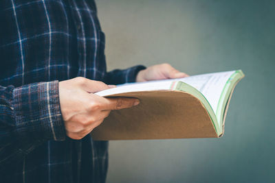 Midsection of man holding book