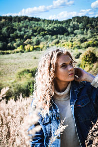 Woman with curly hair standing outdoors