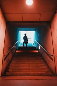 Low angle view of mid adult man moving down on steps