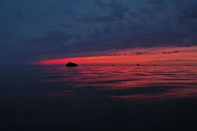 Scenic view of sea against dramatic sky during sunset