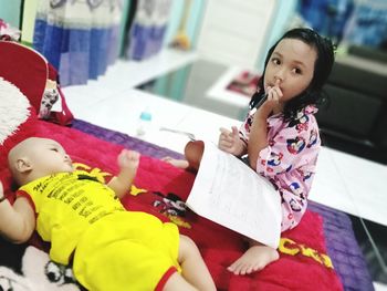 Portrait of cute girl sitting with toy at home