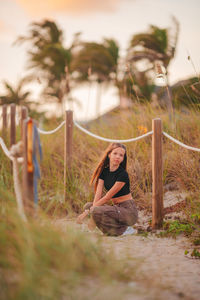 Side view of woman sitting on field