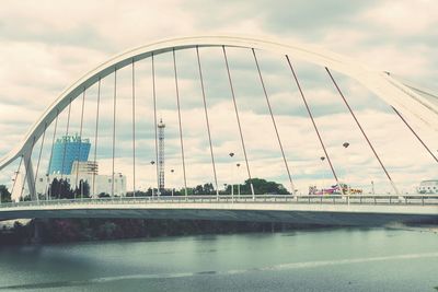 View of bridge over river against cloudy sky