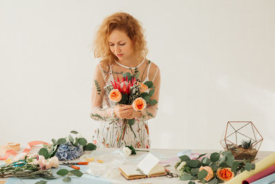 Woman looking at camera on table against white background