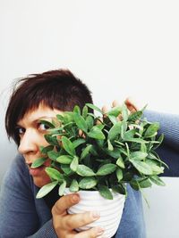 Young woman holding leaf over white background