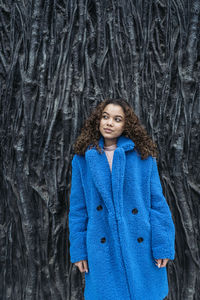 Portrait of teenage girl standing against tree