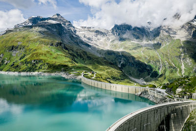 Scenic view of lake by mountains against sky