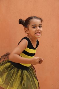 Portrait of cute girl making face by wall