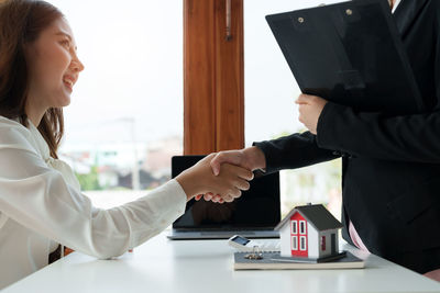 Business colleagues shaking hands in office