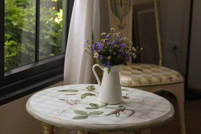 Close-up of flower vase on table at home