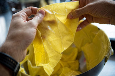 Close-up of hand holding yellow leaf