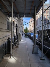 Empty footpath amidst buildings in city