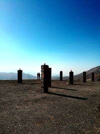 Built structure on landscape against clear blue sky