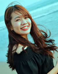 Portrait of smiling young woman at beach