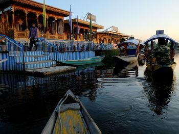 Boats moored in canal against sky