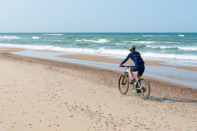 Man riding bicycle on beach