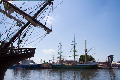 Sailboats moored in sea against sky