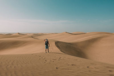 Rear view of man walking in desert