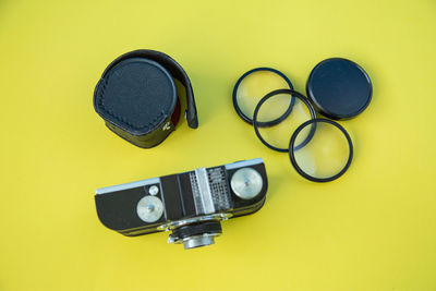 High angle view of camera on table against yellow background