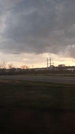 Scenic view of field against cloudy sky