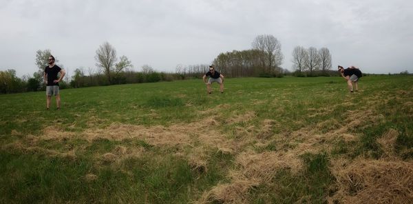 Multiple image of man standing on field against sky