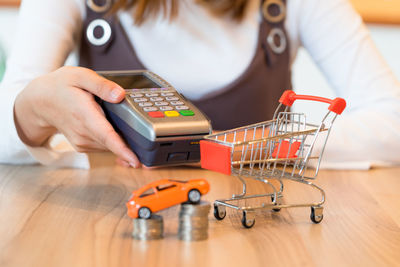 Midsection of woman holding card reader at table