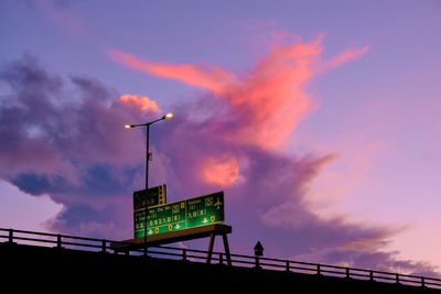 Low angle view of illuminated street light against sky at sunrise