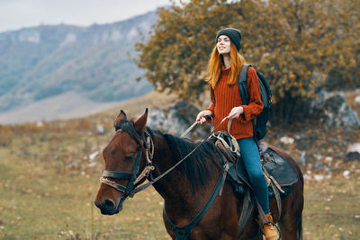 Young woman riding horse