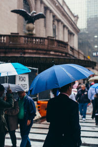 People walking on wet street during rainy season