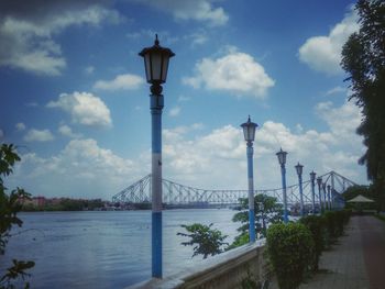 Bridge over river against cloudy sky