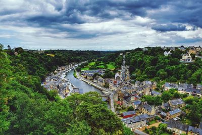 High angle view of river amidst trees in town against sky