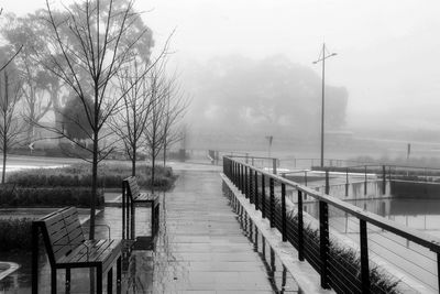 Footbridge over canal against sky during winter