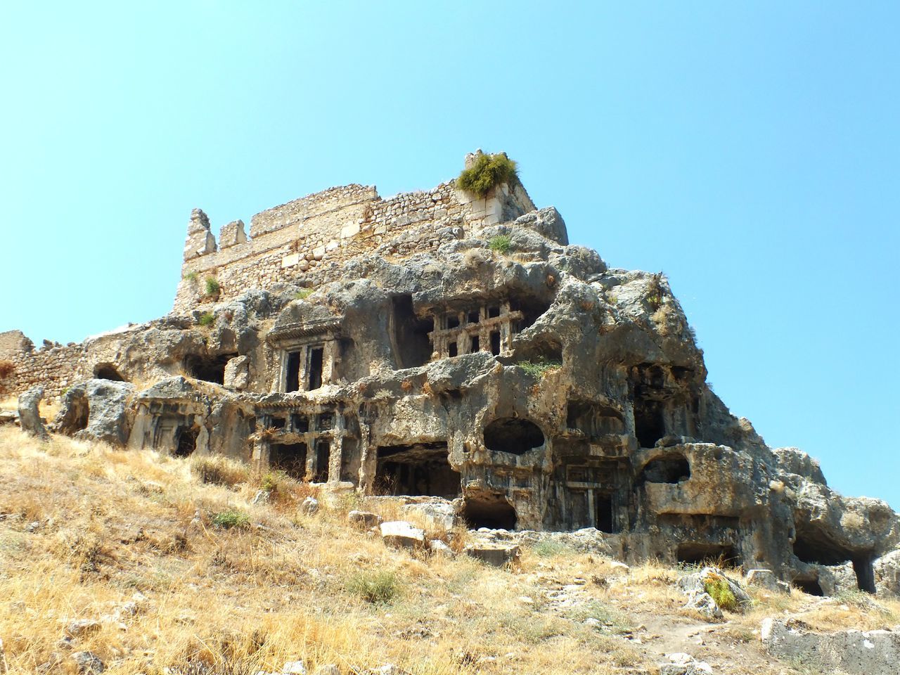 old ruin, history, clear sky, rock - object, ancient civilization, ancient, low angle view, the past, day, archaeology, architecture, built structure, tourism, no people, travel destinations, sunlight, outdoors, blue, nature, mountain, sky