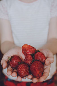 Close-up of hand holding strawberries