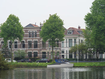 Building by river against sky