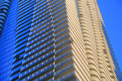 Low angle view of modern building against clear blue sky