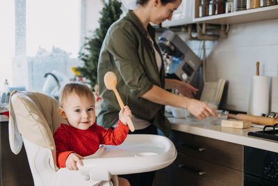 Cozy christmas at home. family preparation holiday dessert. mother and baby toddler daughter play