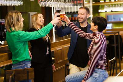 Friends toasting drinks drinks at bar