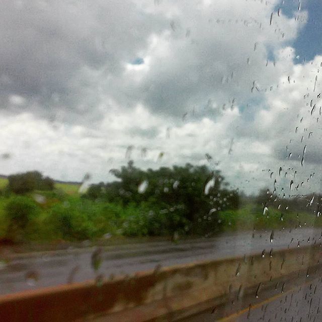 wet, drop, water, sky, rain, transparent, glass - material, weather, window, transportation, cloud - sky, raindrop, car, road, nature, tree, cloudy, land vehicle, monsoon, vehicle interior