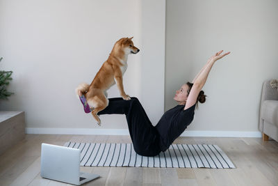 Young woman with cat on floor at home