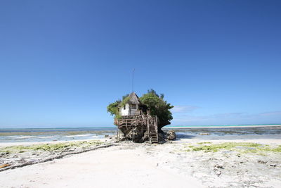 Scenic view of beach against clear blue sky